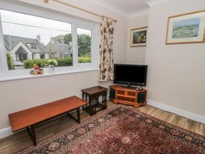 a living room with a large window and a flat screen tv at Bedlinog in Amlwch