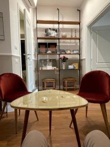 uma sala de estar com uma mesa de vidro e 2 cadeiras em Mia roma centro em Roma
