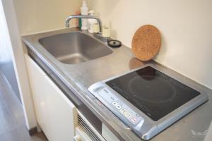 eine Küchentheke mit einer Spüle und einem Herd in der Unterkunft Escort Haruyoshi in Fukuoka + 45 Fotos