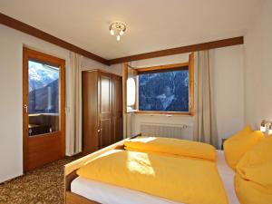1 Schlafzimmer mit 2 Betten und 2 Fenstern in der Unterkunft Apartment Berneckblick by Interhome in Kauns
