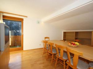 eine Küche und ein Esszimmer mit einem Holztisch und Stühlen in der Unterkunft Apartment Berneckblick by Interhome in Kauns