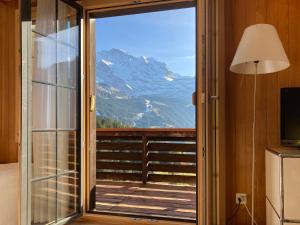 una stanza con una porta scorrevole in vetro con vista sulle montagne di Apartment Jungfrau a d Ledi-1 by Interhome a Wengen Altre 25 foto