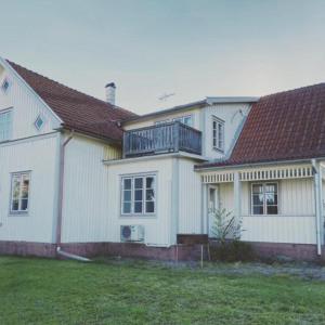 ein weißes Haus mit Balkon darüber in der Unterkunft Villa Löfström in Timmernabben