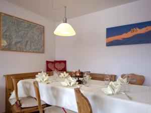 a dining room with a white table with white flowers on it at Apartment Chesa Villasimius by Interhome in Celerina