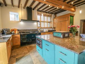 a large kitchen with blue cabinets and counters at High Hall in Skipton
