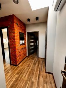an empty room with a brick wall and wooden floors at Apartamenty na Maja - 5 in Skierniewice