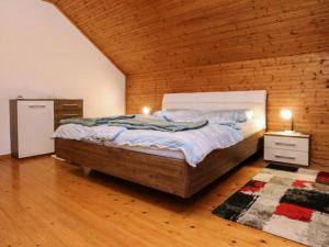 sypialnia z łóżkiem i drewnianą ścianą w obiekcie Apartment Magdalensberg by Interhome w mieście Gröblach