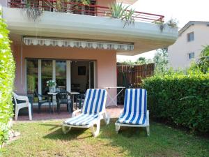 two blue and white chairs sitting in the yard at Apartment App- 17 by Interhome in Caslano