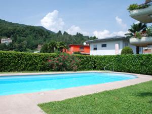 a swimming pool in the yard of a house at Apartment App- 17 by Interhome in Caslano +19 photos