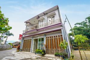 Tlekung的住宿－Super OYO 90642 Lancar Homestay Syariah，街边带阳台的房子