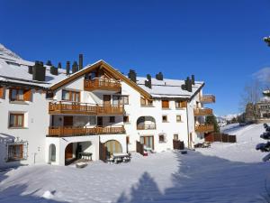 a large white building with snow on the ground at Apartment Chesa Fuolla Verda A8 by Interhome in Celerina