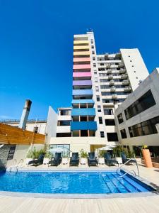 a building with a swimming pool in front of a building at Gran Cavancha Suite in Iquique