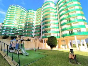 a apartment building with a playground in front of it at Apartment Vila Park by Interhome in Cala de Finestrat