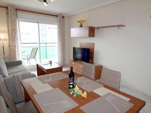 a living room with a table with a bottle of wine at Apartment Vila Park by Interhome in Cala de Finestrat