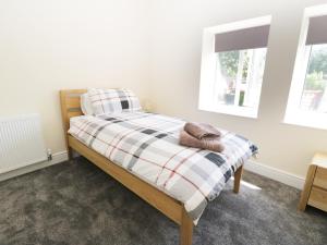 a bed in a room with two windows at White Rose Cottage in Guisborough