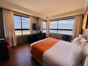 una camera d'albergo con un grande letto e ampie finestre di Gran Cavancha Suite a Iquique