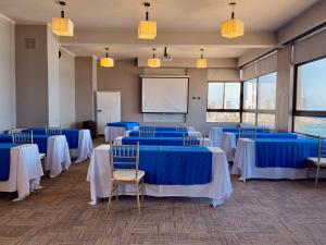 una sala conferenze con tavoli e sedie blu e schermo di Gran Cavancha Suite a Iquique Altre 37 foto