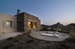 a stone house with a bench in a yard at Thalatta Thalatta in Otzias