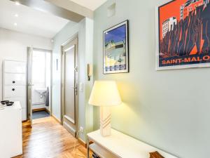 een woonkamer met een tafel en een lamp bij Apartment Grands Degrès by Interhome in Saint-Malo