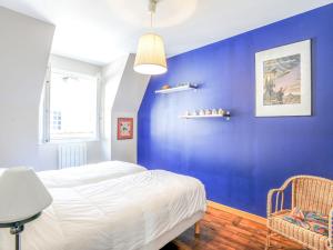 een blauwe slaapkamer met een bed en een stoel bij Apartment Grands Degrès by Interhome in Saint-Malo