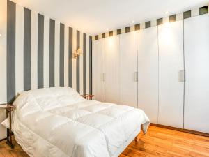 サン・マロにあるApartment Grands Degrès by Interhomeの白いベッドとストライプの壁が備わるベッドルーム1室