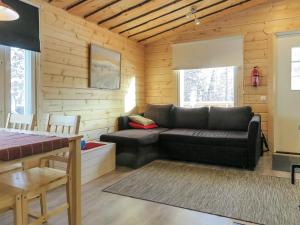 a living room with a black couch in a log cabin at Holiday Home Poromies d by Interhome in Saariselka