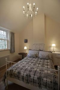 ein Schlafzimmer mit einem Bett und einem Kronleuchter in der Unterkunft Riverside cottage walking distance into Caernarfon in Caernarfon