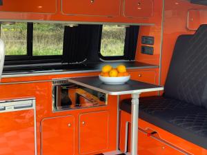 Kirk Braddon的住宿－Campervan and Motorhome Hire Isle of Man，一只橙子放在桌子上的一碗rv