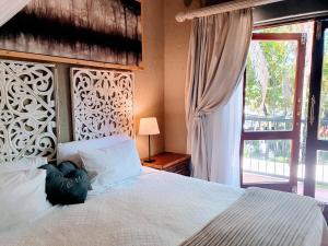 a bedroom with a large white bed with a window at Waterhouse Guest Lodge - Indus Street in Pretoria