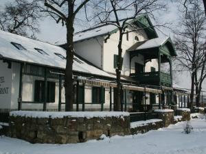 a building with a gazebo in the snow at Svájci Lak Panzió in Nyíregyháza