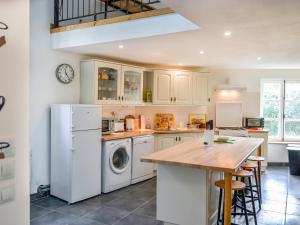 a kitchen with white appliances and a wooden table at Holiday Home L'Ancienne Scierie by Interhome in Saint-Martin-sur-Armançon