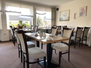 a dining room with a table and chairs in a restaurant at Hotel zum Rosenteich in Bad Zwischenahn