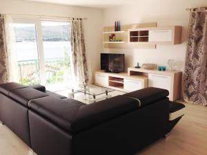 sala de estar con sofá y ventana grande en D'Angellis Livaja Apartments, en Trogir