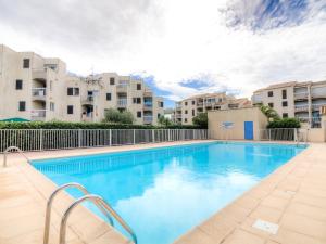 a swimming pool with buildings in the background at Apartment Les Frégates by Interhome in Saint-Cyprien-Plage