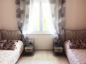 1 dormitorio con 2 camas frente a una ventana en D'Angellis Livaja Apartments, en Trogir