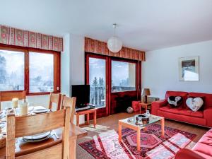 a living room with a red couch and a table at Apartment Fleurs des Alpes-1 by Interhome in Saint-Gervais-les-Bains