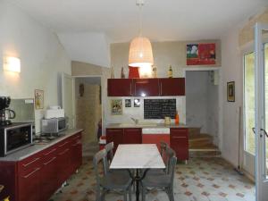 アルジエにあるHoliday Home La Ca Bonita by Interhomeのキッチン(赤いキャビネット、テーブル、椅子付)