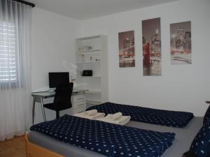 a bedroom with two beds and a desk with a computer at Apartment Saleggi Apt- 20 by Interhome in Locarno