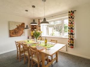 a dining room with a wooden table and chairs at Bransmead in Wareham