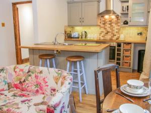 a kitchen with a couch and a table in a room at Gardeners Cottage in Nantwich