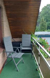 two chairs sitting on the porch of a house at Annelieses Ferienwohnungen in Schneverdingen