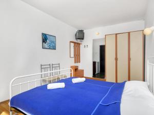 ein Schlafzimmer mit einem blauen Bett mit zwei Kissen darauf in der Unterkunft Apartment Cico-1 by Interhome in Selca kod Bogomolja