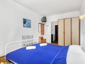 een slaapkamer met een blauw bed met 2 kussens erop bij Apartment Cico-1 by Interhome in Selca kod Bogomolja