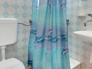 een blauw douchegordijn in een badkamer met een toilet bij Apartment Cico-1 by Interhome in Selca kod Bogomolja +5 foto's