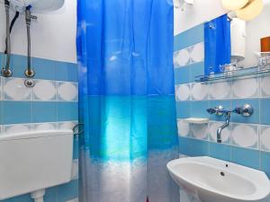 een badkamer met een blauw douchegordijn en een wastafel bij Apartment Cico-3 by Interhome in Selca kod Bogomolja +5 foto's