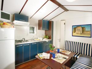 kuchnia z niebieskimi szafkami i drewnianym stołem w obiekcie Holiday Home Cecina Mare-15 by Interhome w mieście Marina di Cecina