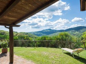 un banc sur une terrasse avec des montagnes en arrière-plan dans l'établissement Holiday Home Casale Belvedere by Interhome, à Roccastrada