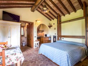 a bedroom with a blue bed and a kitchen at Holiday Home Casale Belvedere by Interhome in Roccastrada +8 photos