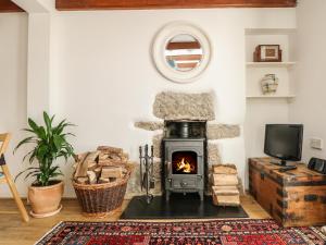 
a living room filled with furniture and a fire place at Westerly Cottage, Penzance in Penzance
