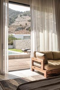 a living room with a couch and a large window at Casa Cook Rhodes (Adults Only) in Kolimbia